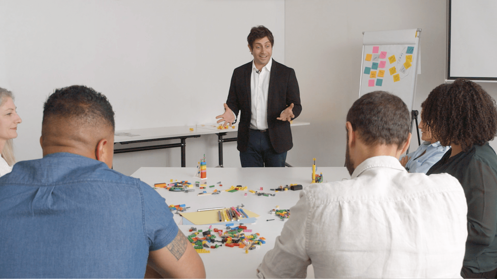 A facilitator leading a LEGO Serious Play workshop with a team.