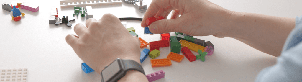 Person building models with LEGO bricks