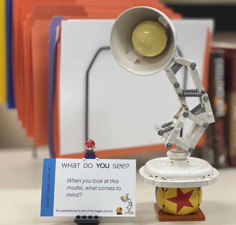 A small LEGO model of the Pixar lamp on a desk.