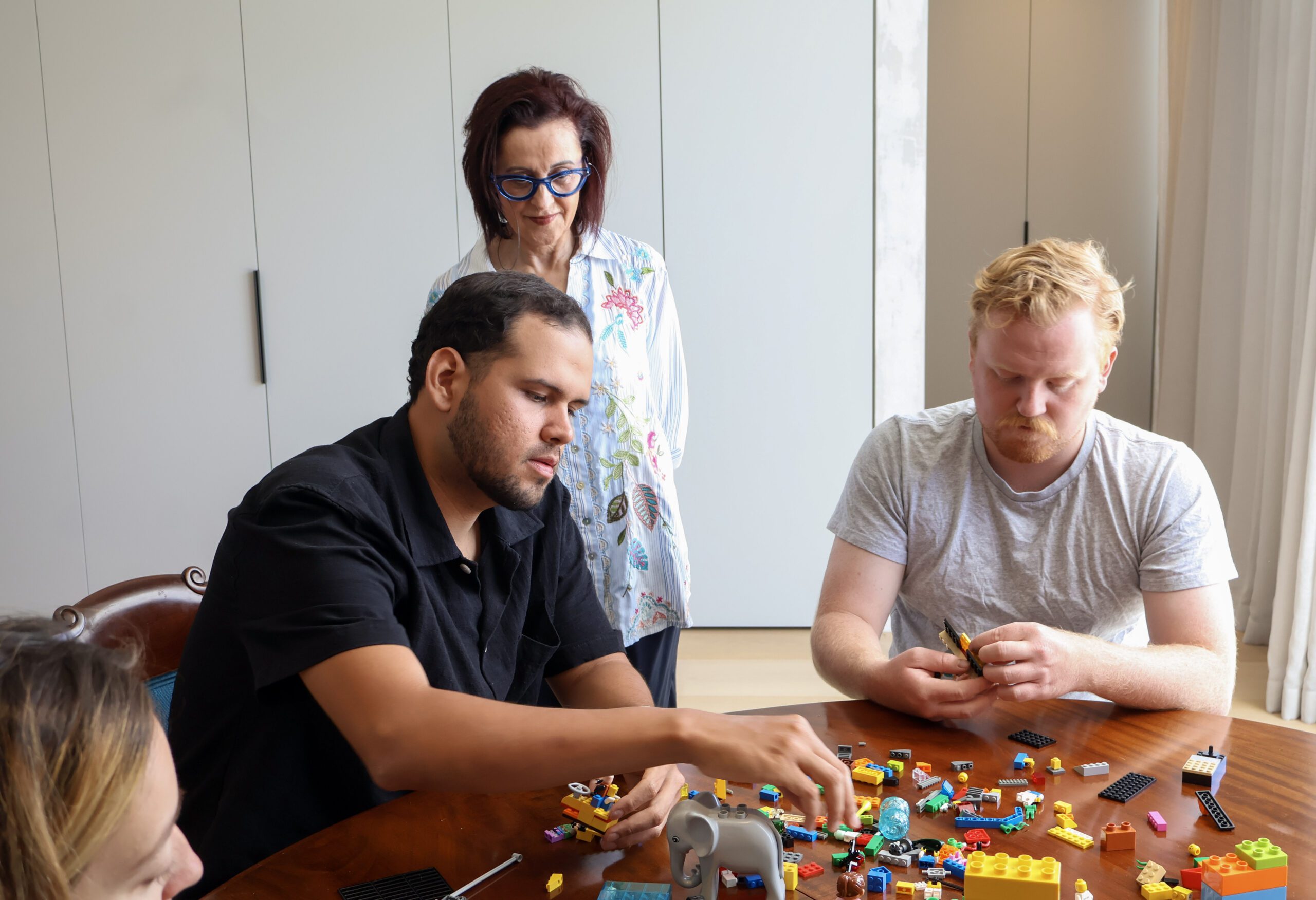 Close up of hands building a complex LEGO structure.